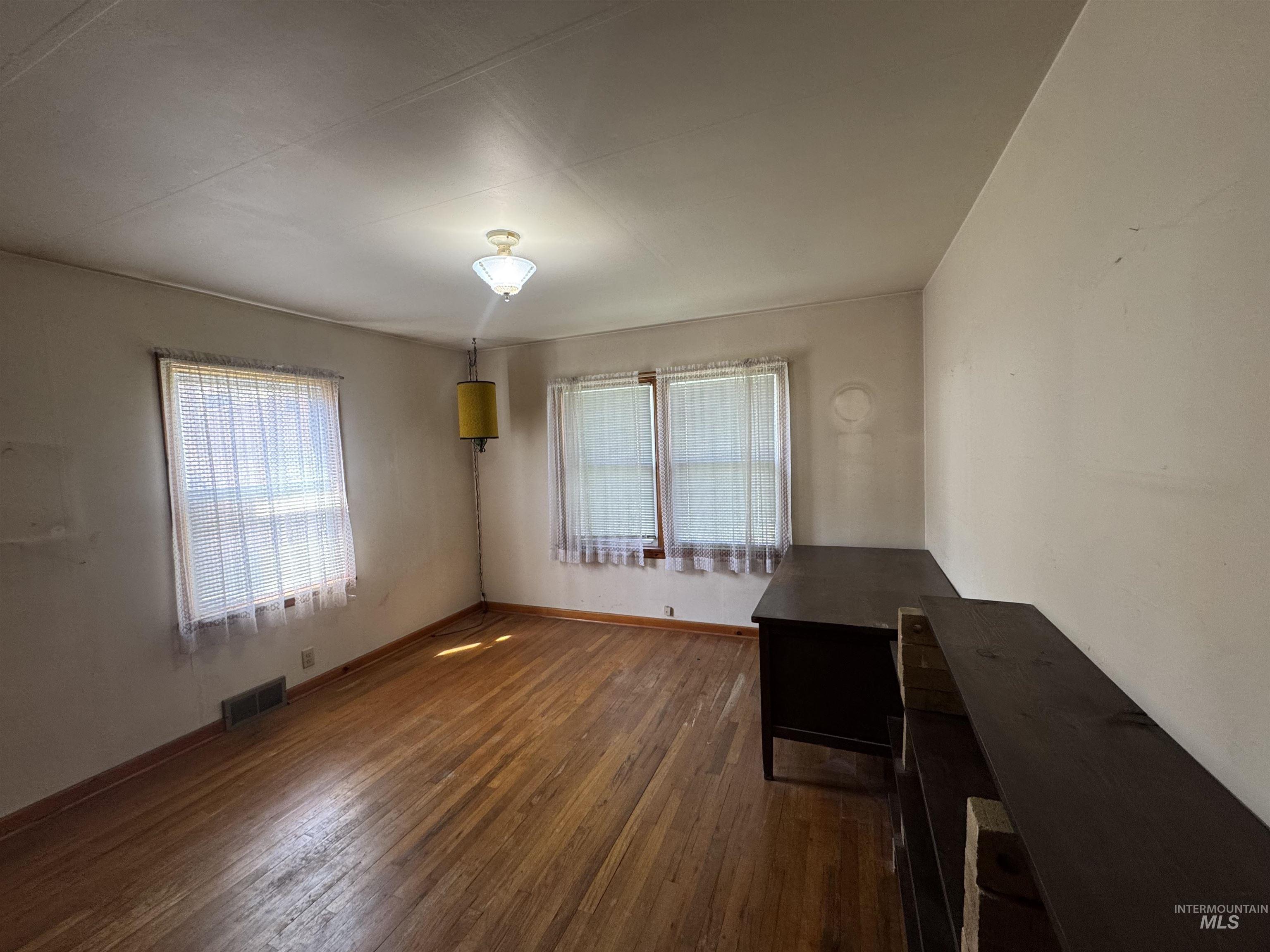 1109 3rd Street Kamiah, ID 83536 - Photo 11 of 21 Unfurnished room with dark wood-type flooring and baseboards
