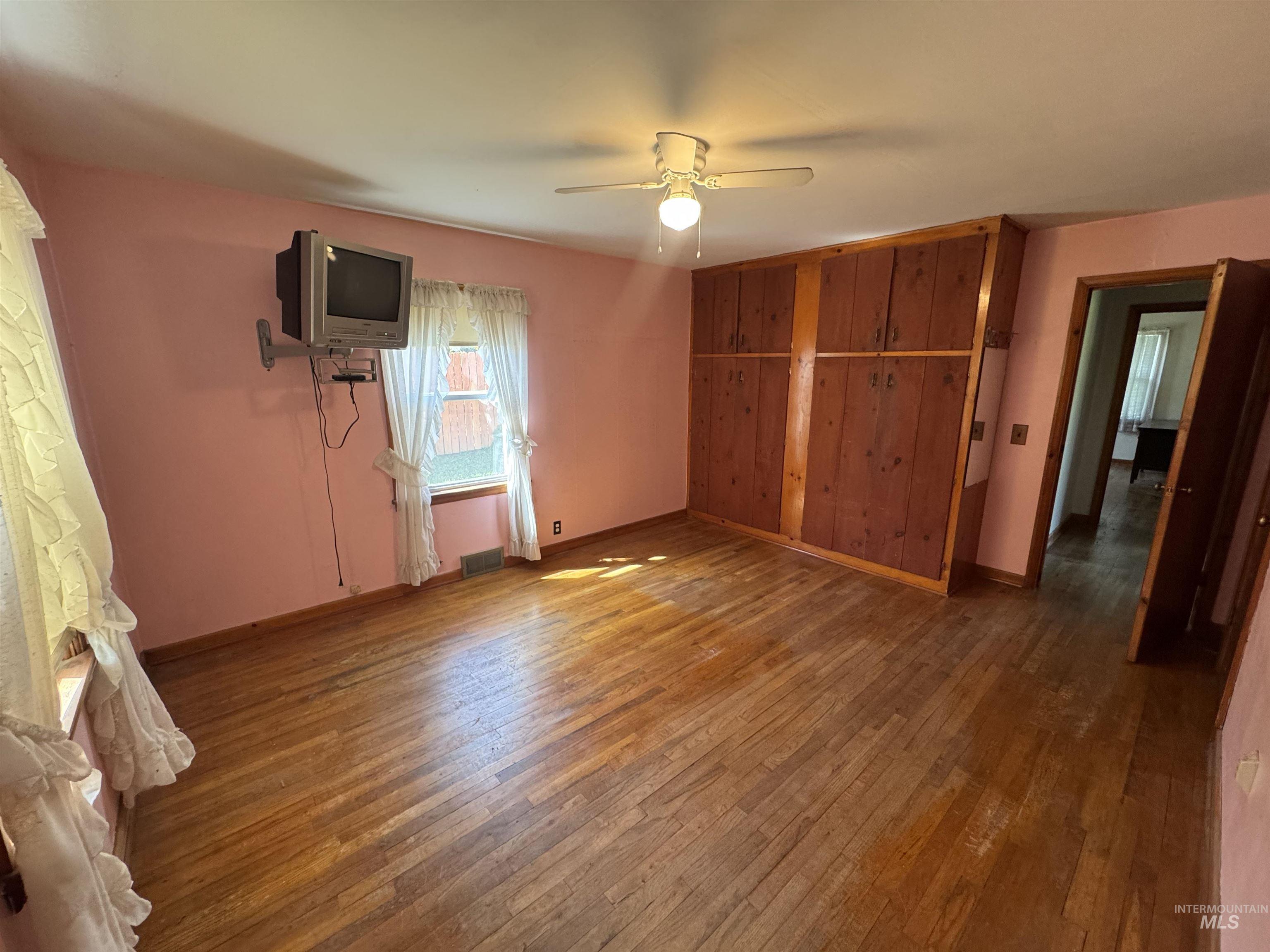 1109 3rd Street Kamiah, ID 83536 - Photo 13 of 21 Unfurnished bedroom featuring dark wood-style flooring, ceiling fan, and a closet