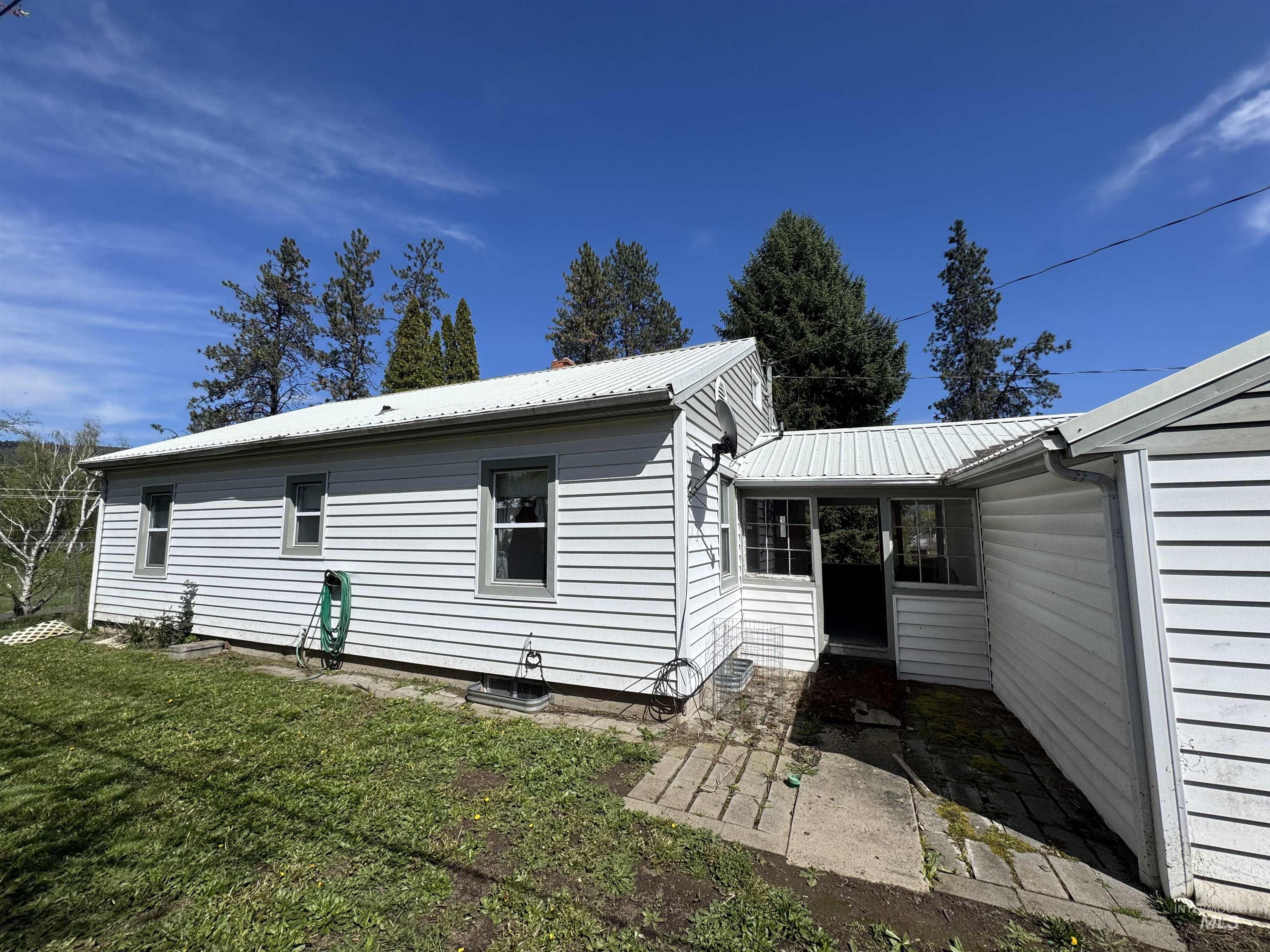 1109 3rd Street Kamiah, ID 83536 - Photo 5 of 21 Rear view of property featuring a metal roof, a yard, and a patio area