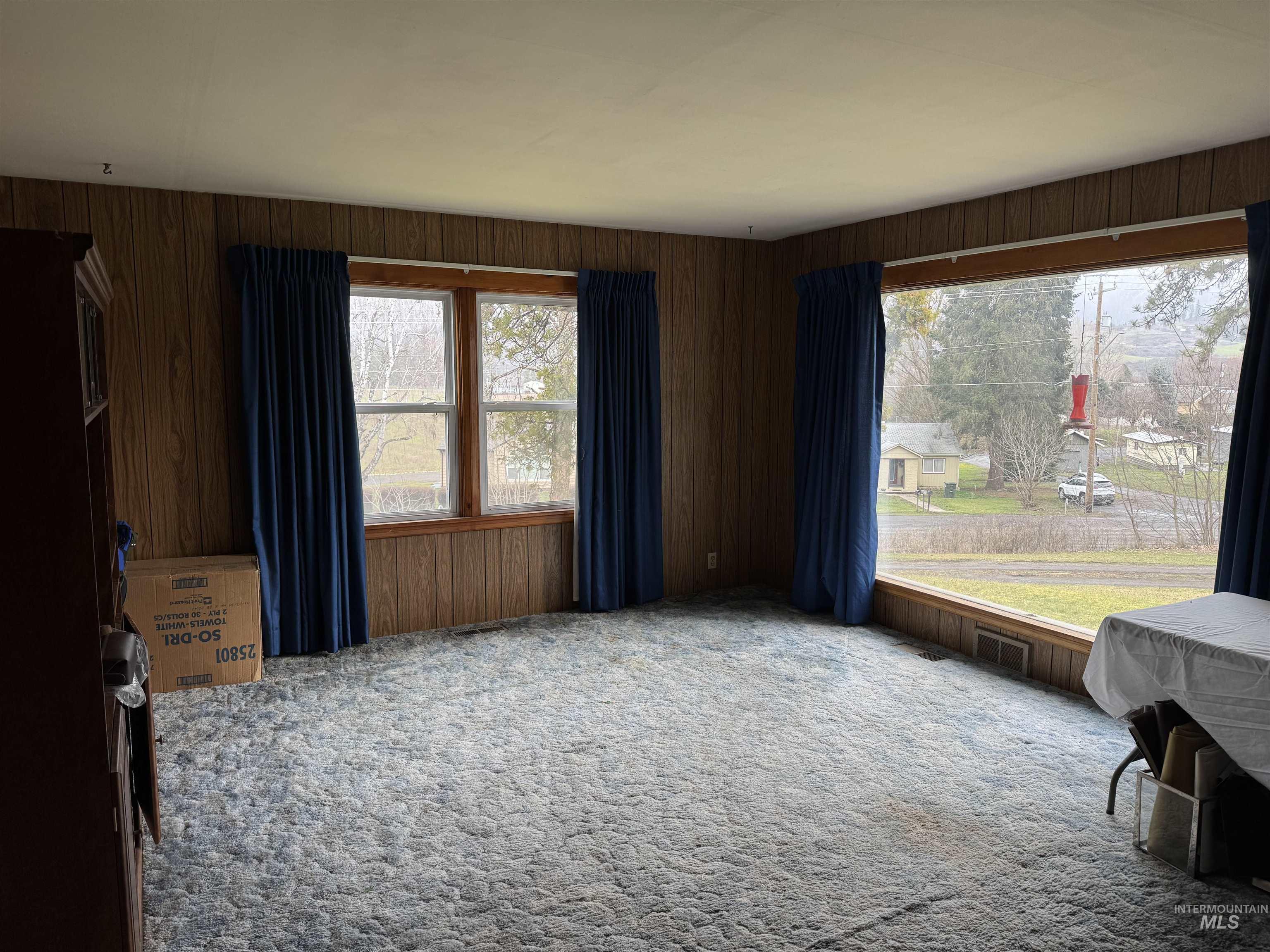 1109 3rd Street Kamiah, ID 83536 - Photo 10 of 21 Carpeted spare room featuring plenty of natural light and wood walls