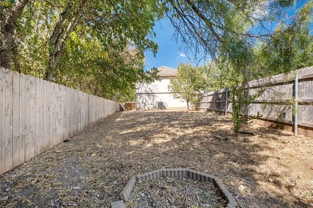 a view of a yard with wooden fence