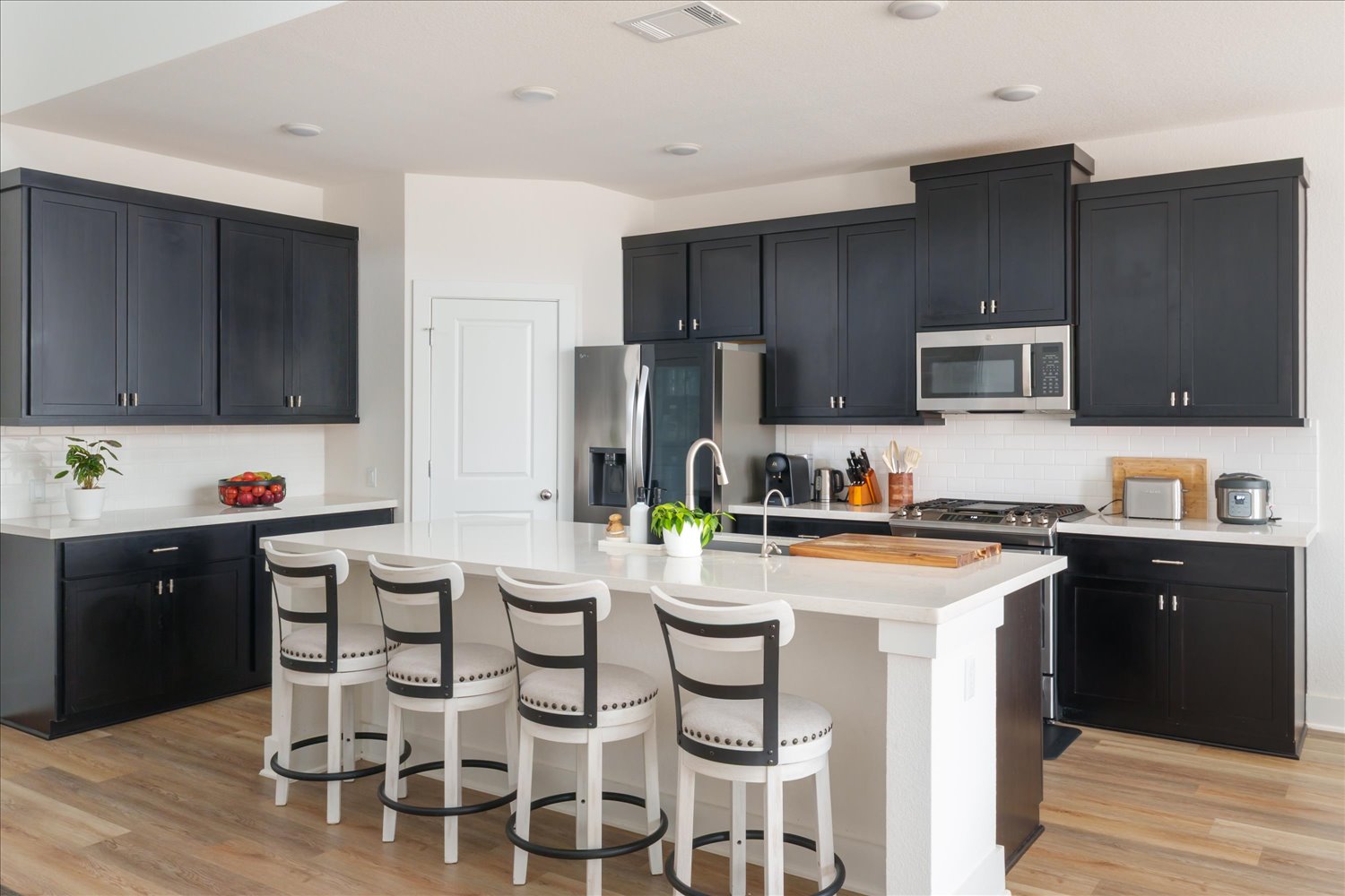 3120 Pale Rider Pass Leander, TX 78641 - Photo 11 of 34 Kitchen with dark cabinetry, tasteful backsplash, and a breakfast bar