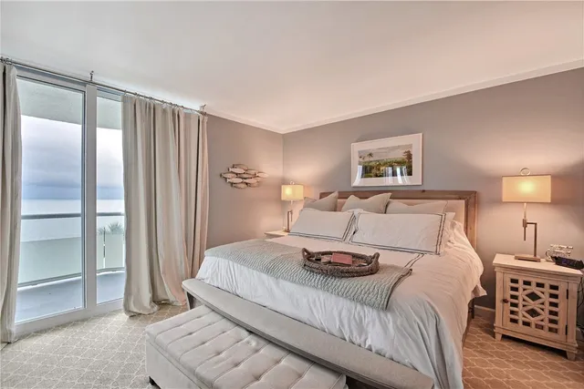 a bedroom with a bed a mirror and lamp