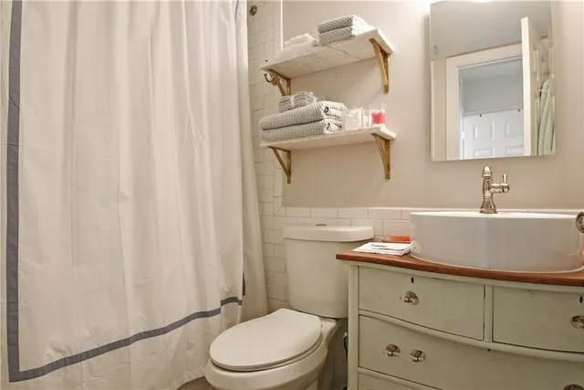 a dining room with wooden floor a chandelier a glass table and chairs