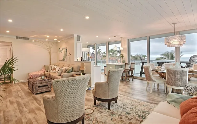 a view of a dining room with furniture a chandelier and wooden floor