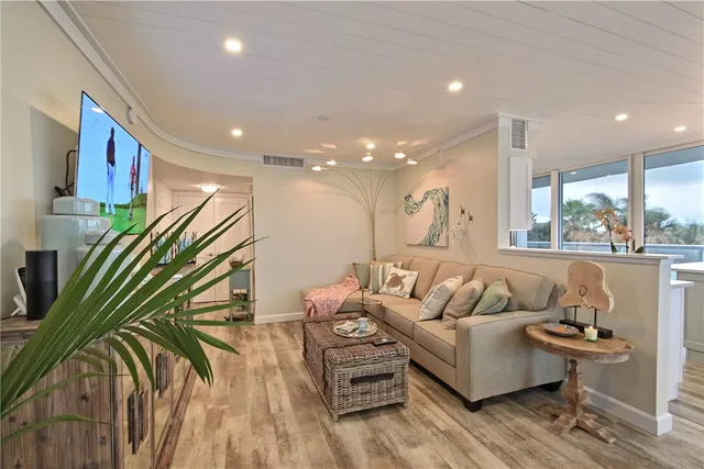 a living room with furniture and a large window with wooden floor