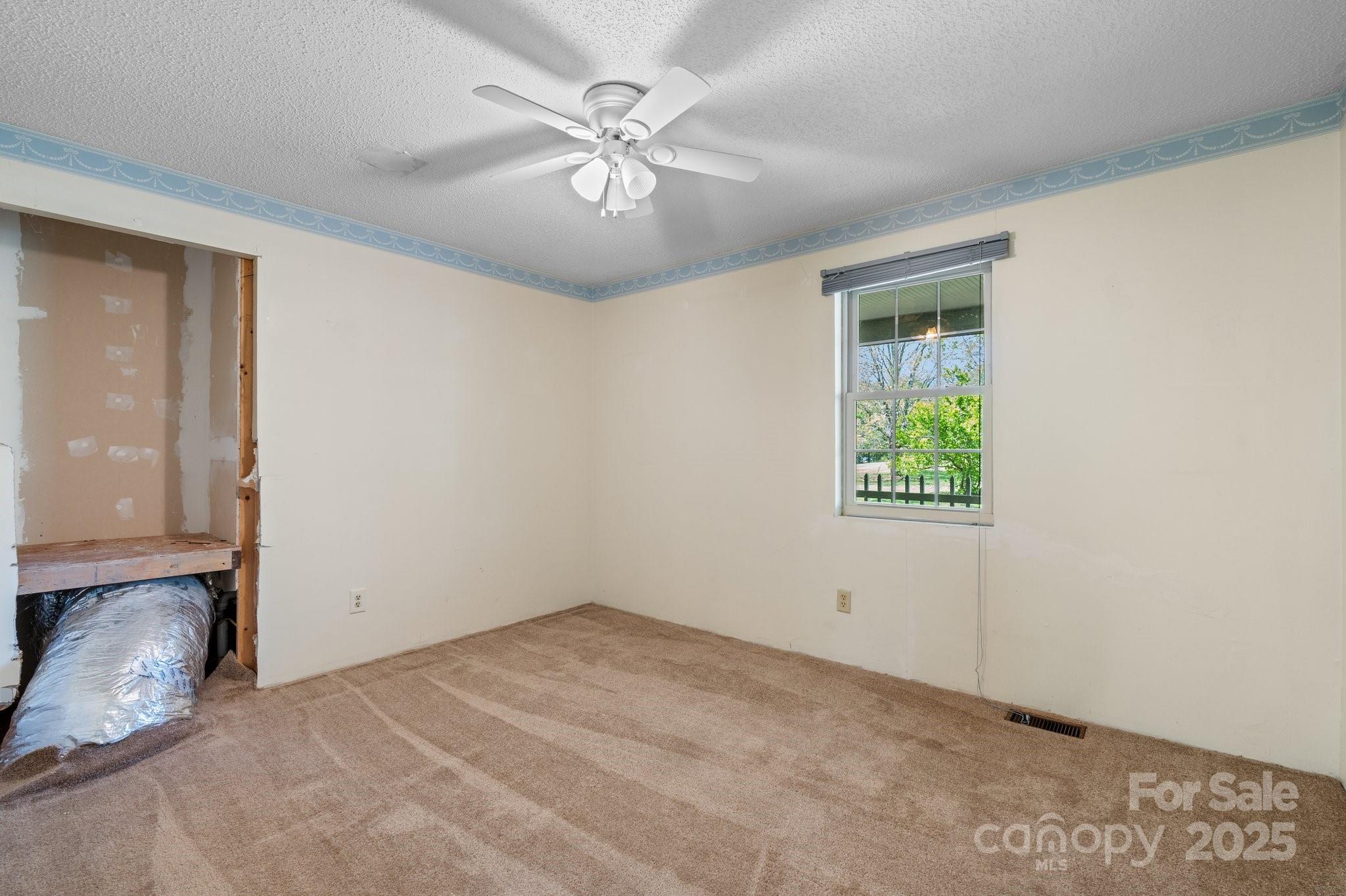 4067 Old Buff Road Hickory, NC 28602 - Photo 26 of 45 an empty room with a chandelier fan and windows