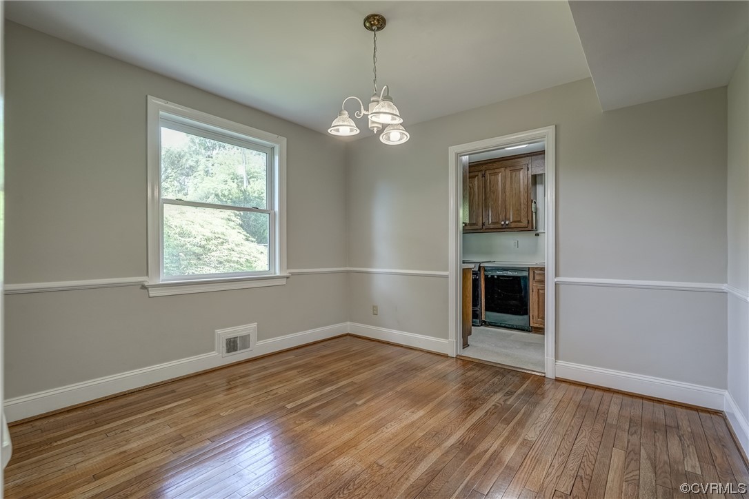 1802 Bremo Road Richmond, VA 23226 - Photo 10 of 50 an empty room with wooden floor chandelier and windows