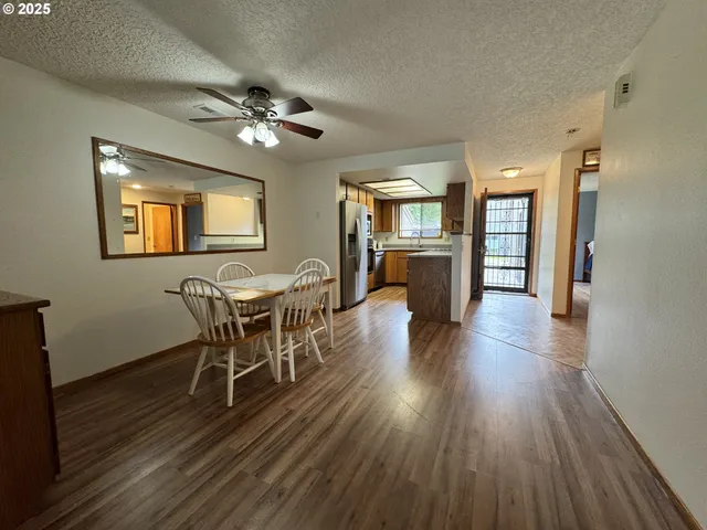 a dining room with furniture a chandelier and wooden floor