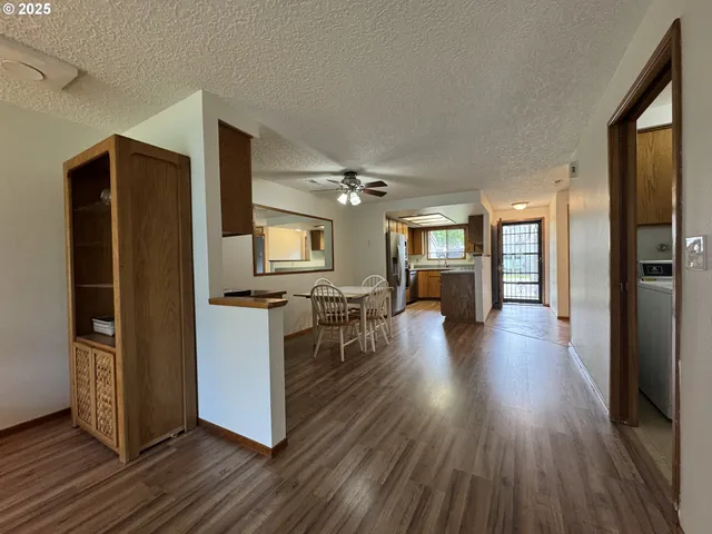 a living room with stainless steel appliances kitchen island furniture and wooden floor