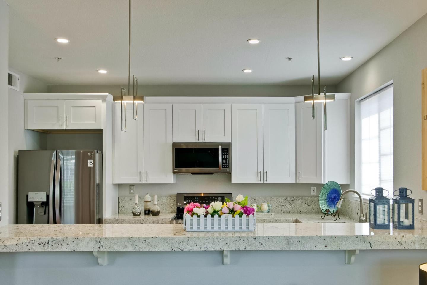 935 Old County Road, Unit 44 Belmont, CA 94002 - Photo 17 of 57 a kitchen with kitchen island granite countertop a sink a counter top space cabinets and stainless steel appliances