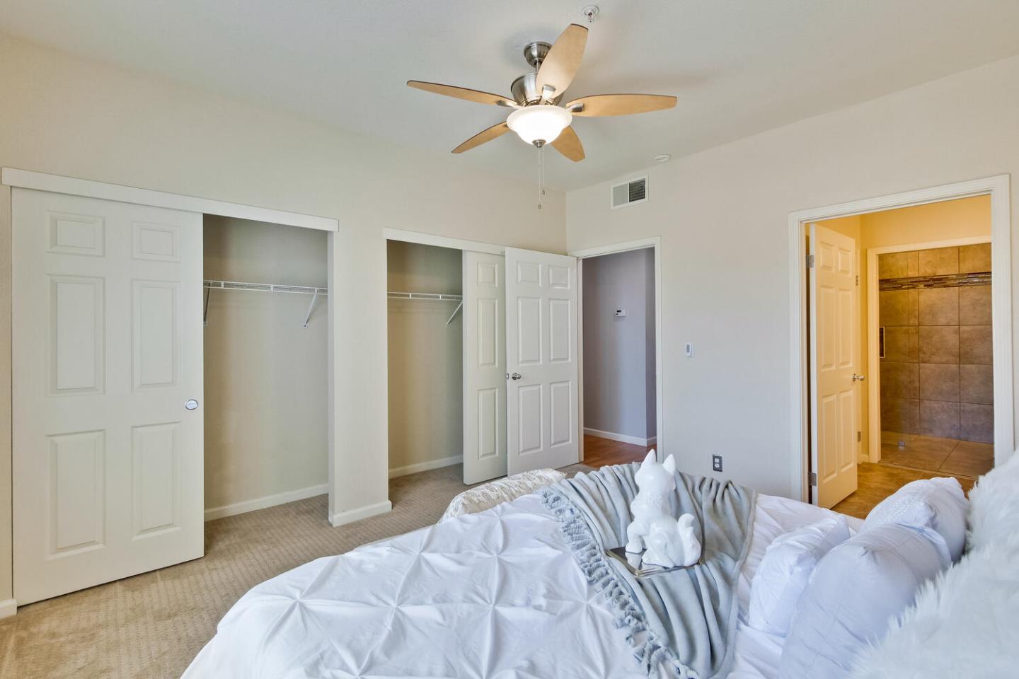 935 Old County Road, Unit 44 Belmont, CA 94002 - Photo 29 of 57 a bedroom with a large bed closet and a chandelier