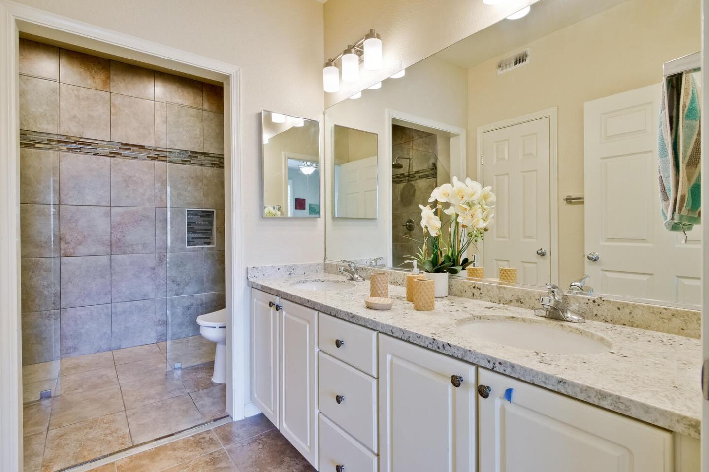 935 Old County Road, Unit 44 Belmont, CA 94002 - Photo 31 of 57 a bathroom with a granite countertop sink a toilet and a mirror