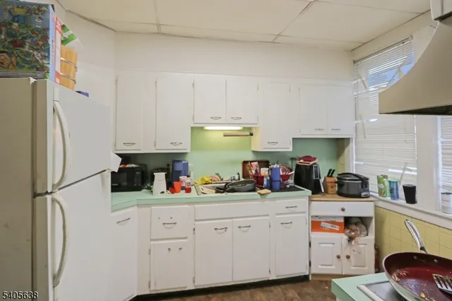 a kitchen with stainless steel appliances white cabinets and a refrigerator