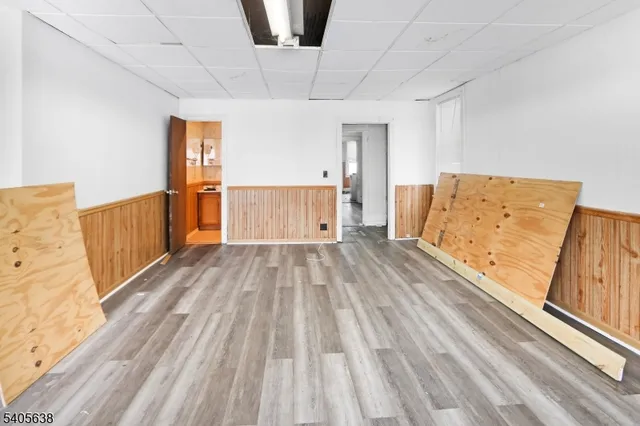 a view of a bedroom with wooden floor and natural light