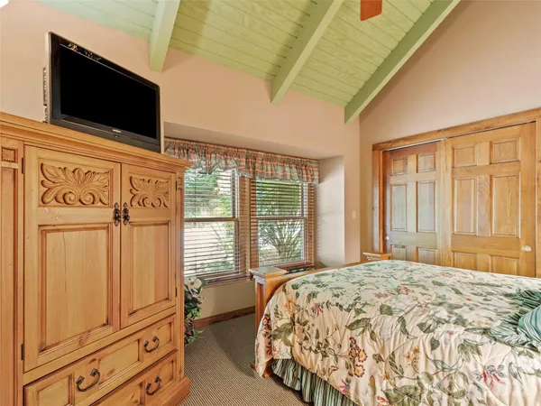 a bedroom with a large bed and tv