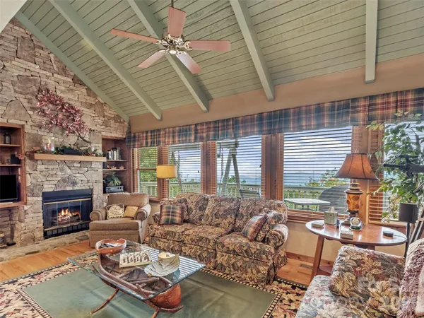 a living room with furniture fireplace and a large window