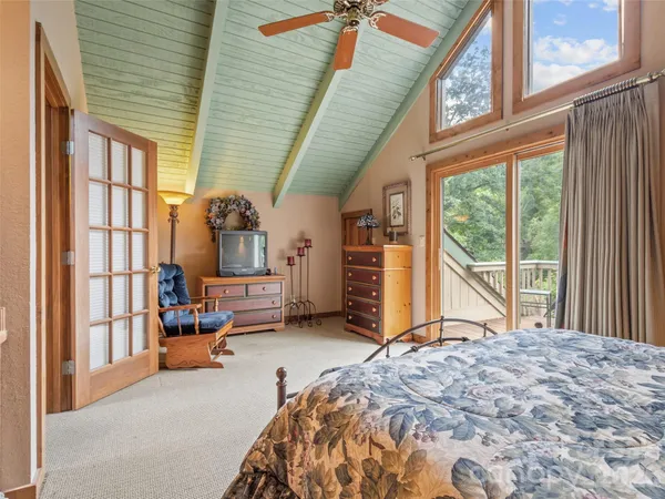 a bedroom with a bed and large windows