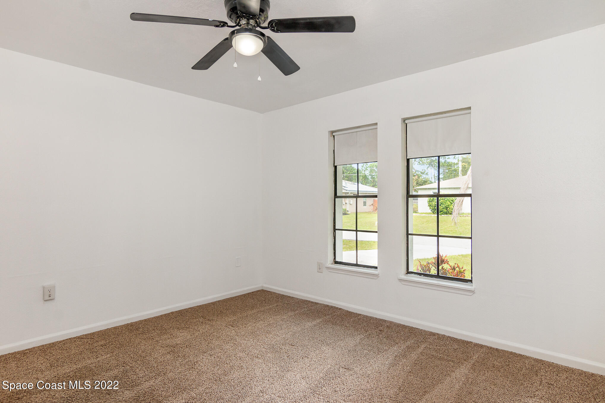 1456 Saxony Road Southwest Palm Bay, FL 32908 - Photo 8 of 22 an empty room with windows and fan