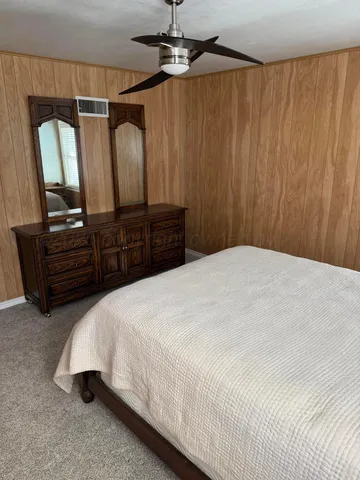 a bedroom with a large bed and a chandelier