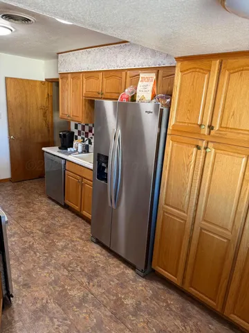 a kitchen with refrigerator a microwave and furniture