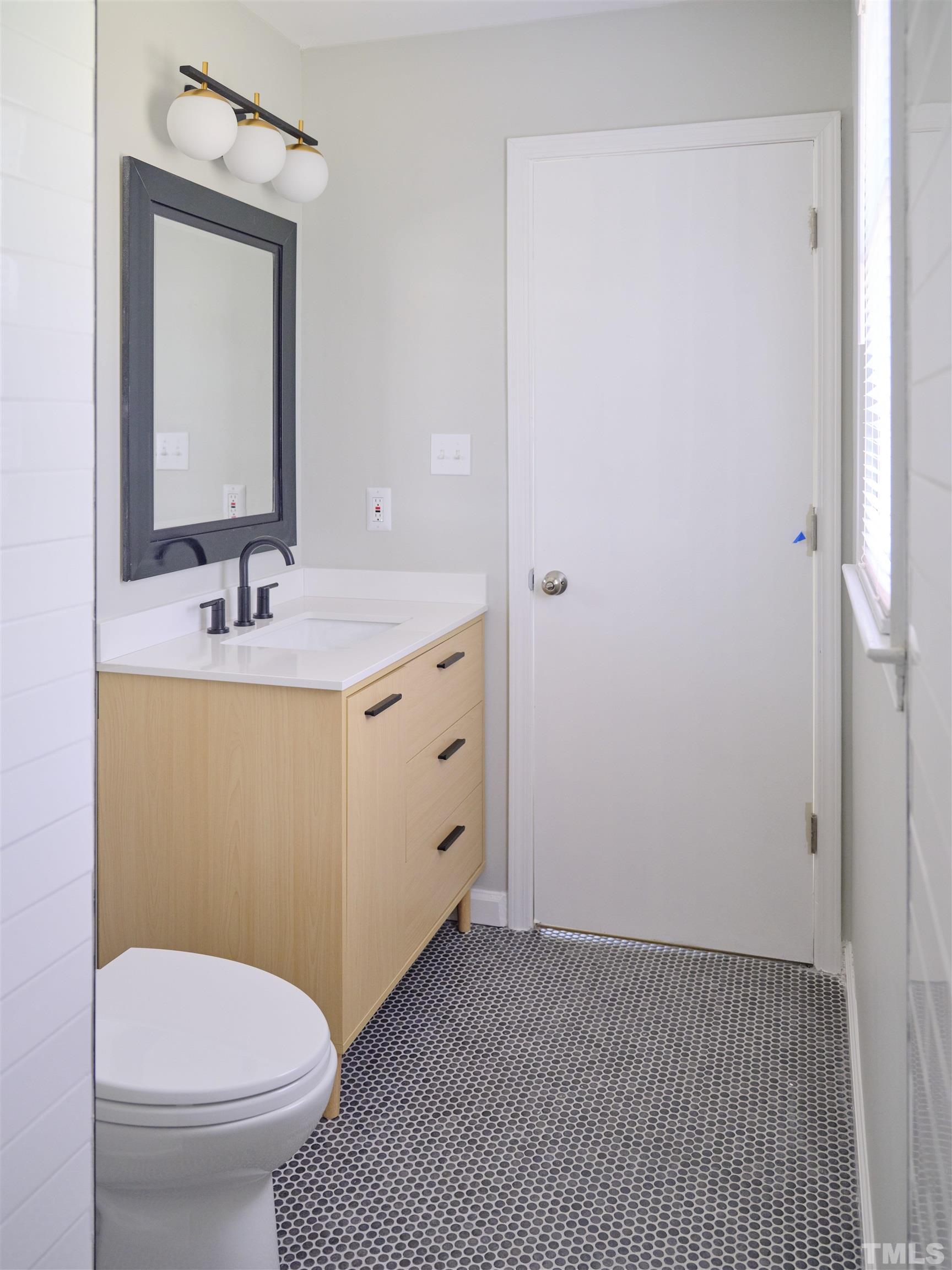 2324 Ravenhill Drive Raleigh, NC 27615 - Photo 17 of 32 a bathroom with a sink toilet and mirror