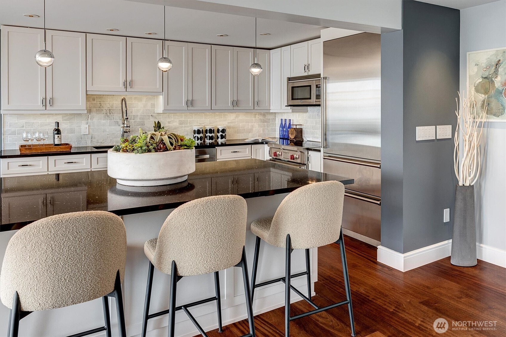 3717 Beach Drive Southwest, Unit 207 Seattle, WA 98116 - Photo 15 of 40 a kitchen with stainless steel appliances granite countertop a refrigerator a stove a sink and white cabinets with wooden floor