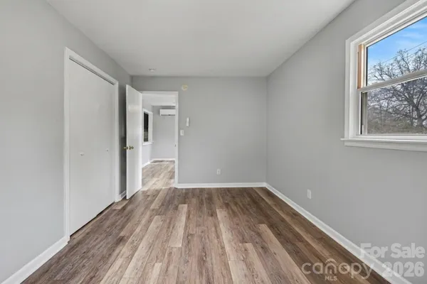 a view of a room with wooden floor and a window