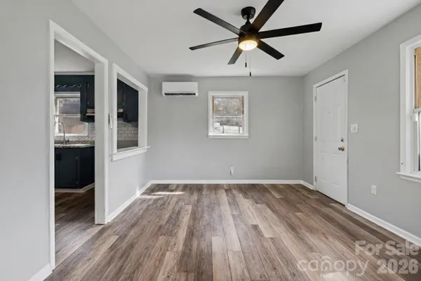 a view of a livingroom with wooden floor and a ceiling fan