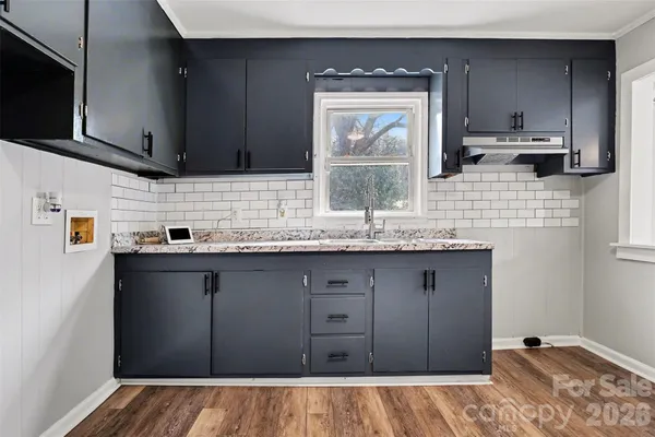 a kitchen with a sink a stove and cabinets