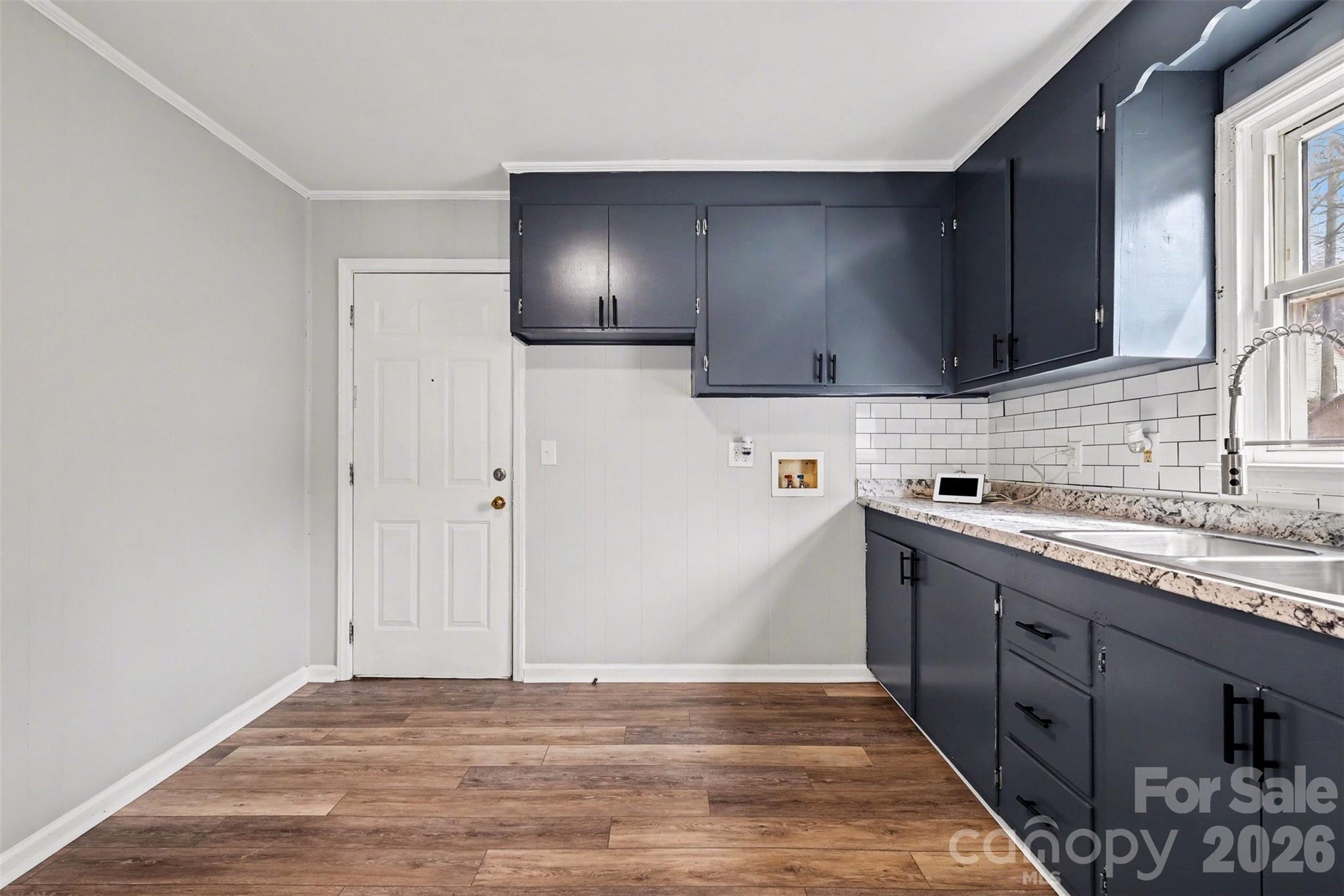1813 Isaac Place Shelby, NC 28152 - Photo 7 of 14 a kitchen with stainless steel appliances granite countertop a sink and a stove top oven with wooden floor