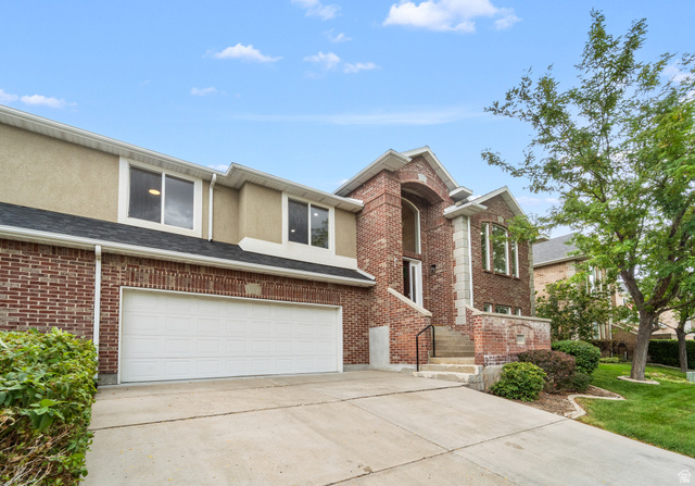340 Brayden Way Draper, UT 84020 - Photo 51 of 58 Brick facade with a two-car garage, concrete driveway, and established landscaping