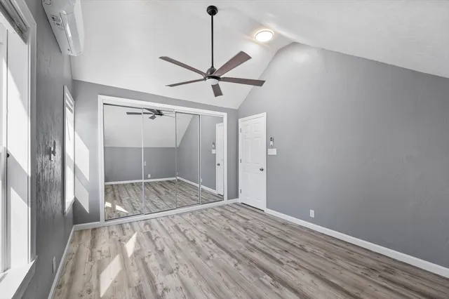 a view of empty room with wooden floor and fan