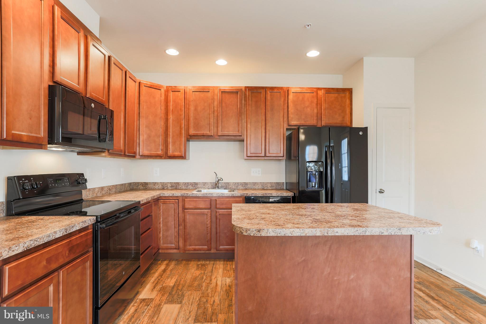 13 Back River Neck Road Baltimore, MD 21221 - Photo 2 of 30 a kitchen with kitchen island granite countertop a sink a counter top space stainless steel appliances and cabinets