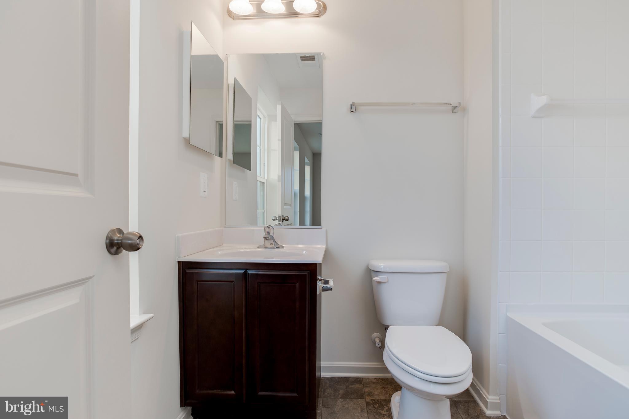 13 Back River Neck Road Baltimore, MD 21221 - Photo 13 of 30 a bathroom with a granite countertop toilet sink and mirror