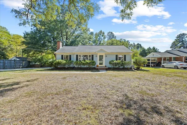 a front view of a house with a yard and potted plants