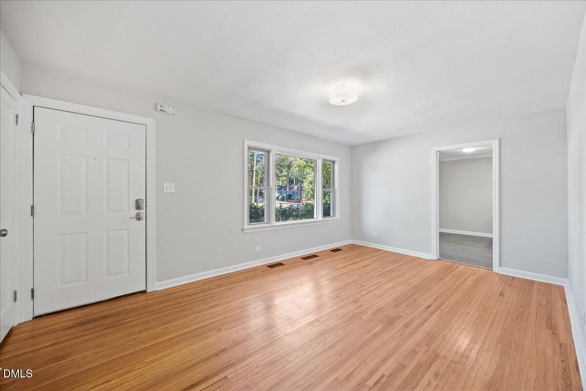 2915 Fawn Avenue Durham, NC 27705 - Photo 7 of 39 a view of an empty room with wooden floor and a window