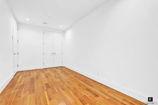 a view of empty room with wooden floor