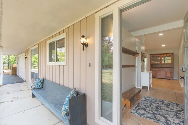 a view of a hallway with wooden floor and a living room