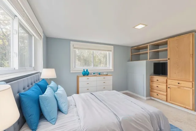 a bedroom with a bed and furniture with window