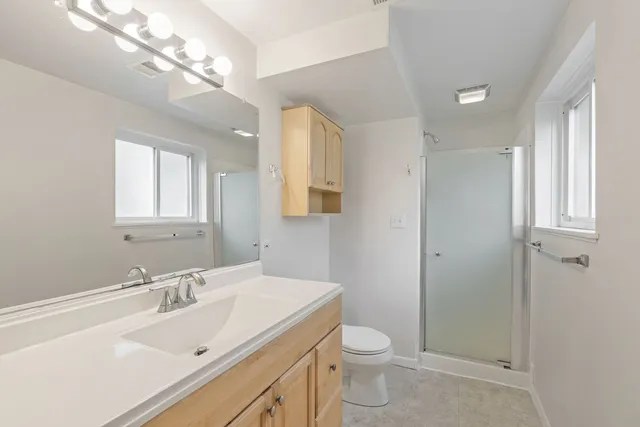 a bathroom with a sink a toilet and shower
