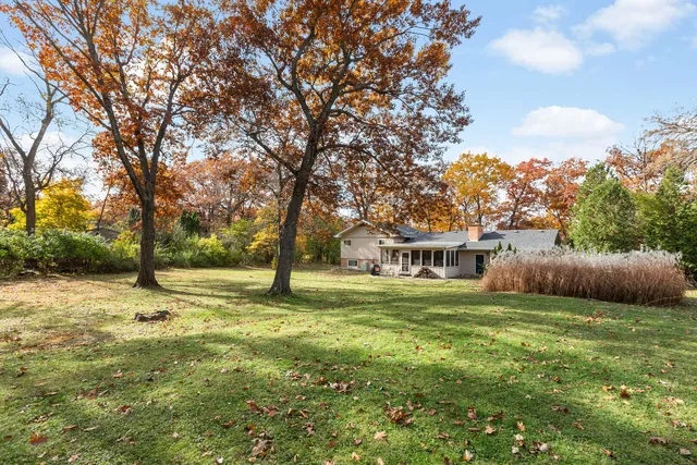 a view of a house with a big yard and a large tree