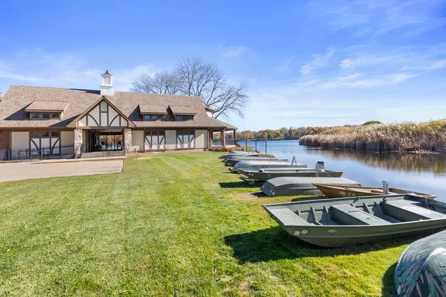 a view of a house with pool and chairs next to a yard