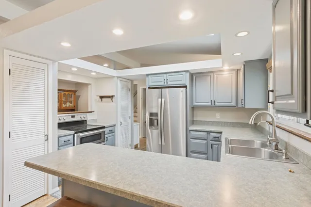 a kitchen with stainless steel appliances granite countertop a sink stove and refrigerator