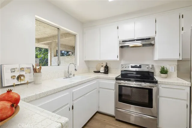 a kitchen with stainless steel appliances granite countertop a sink and a stove