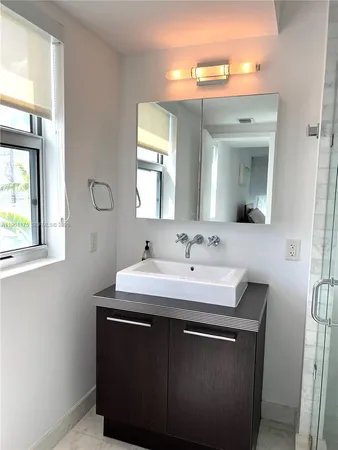 a bathroom with a shower sink and mirror
