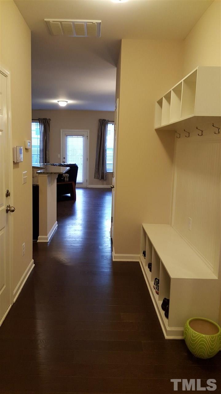 408 Stone Flower Lane Raleigh, NC 27603 - Photo 2 of 20 Entry with door to garage and built-in cabinets. Stairs and half bath to the right.