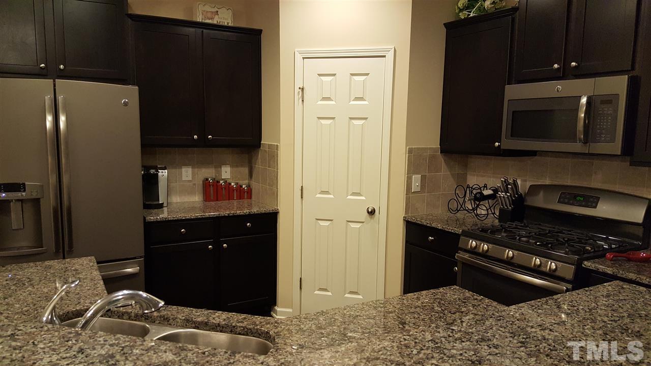 408 Stone Flower Lane Raleigh, NC 27603 - Photo 3 of 20 Slate appliances and gas range, island with sink and walk-in pantry.