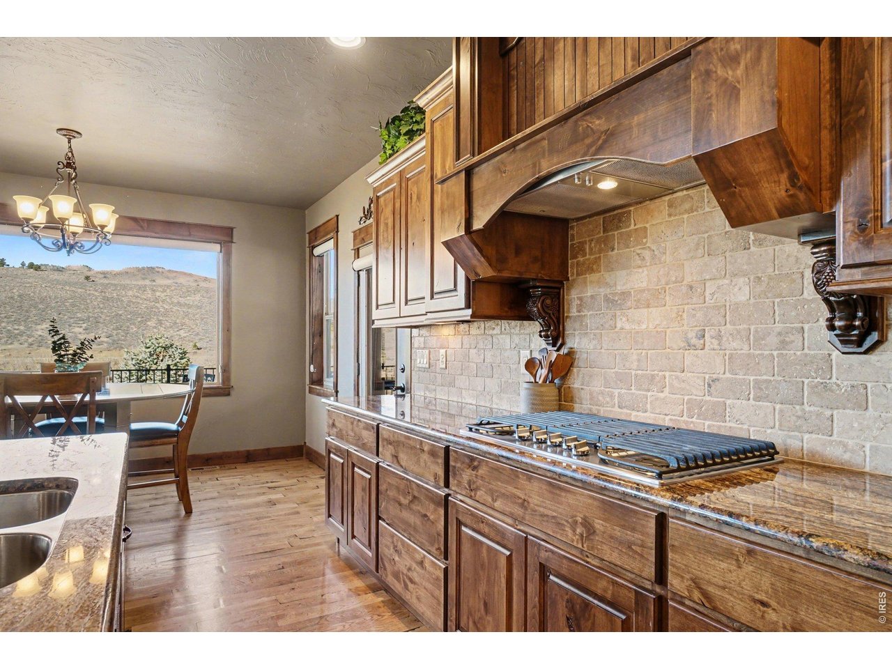 10723 Buckhorn Ridge Way Loveland, CO 80538 - Photo 11 of 50 a kitchen with stainless steel appliances granite countertop a stove a sink dishwasher and cabinets with wooden floor