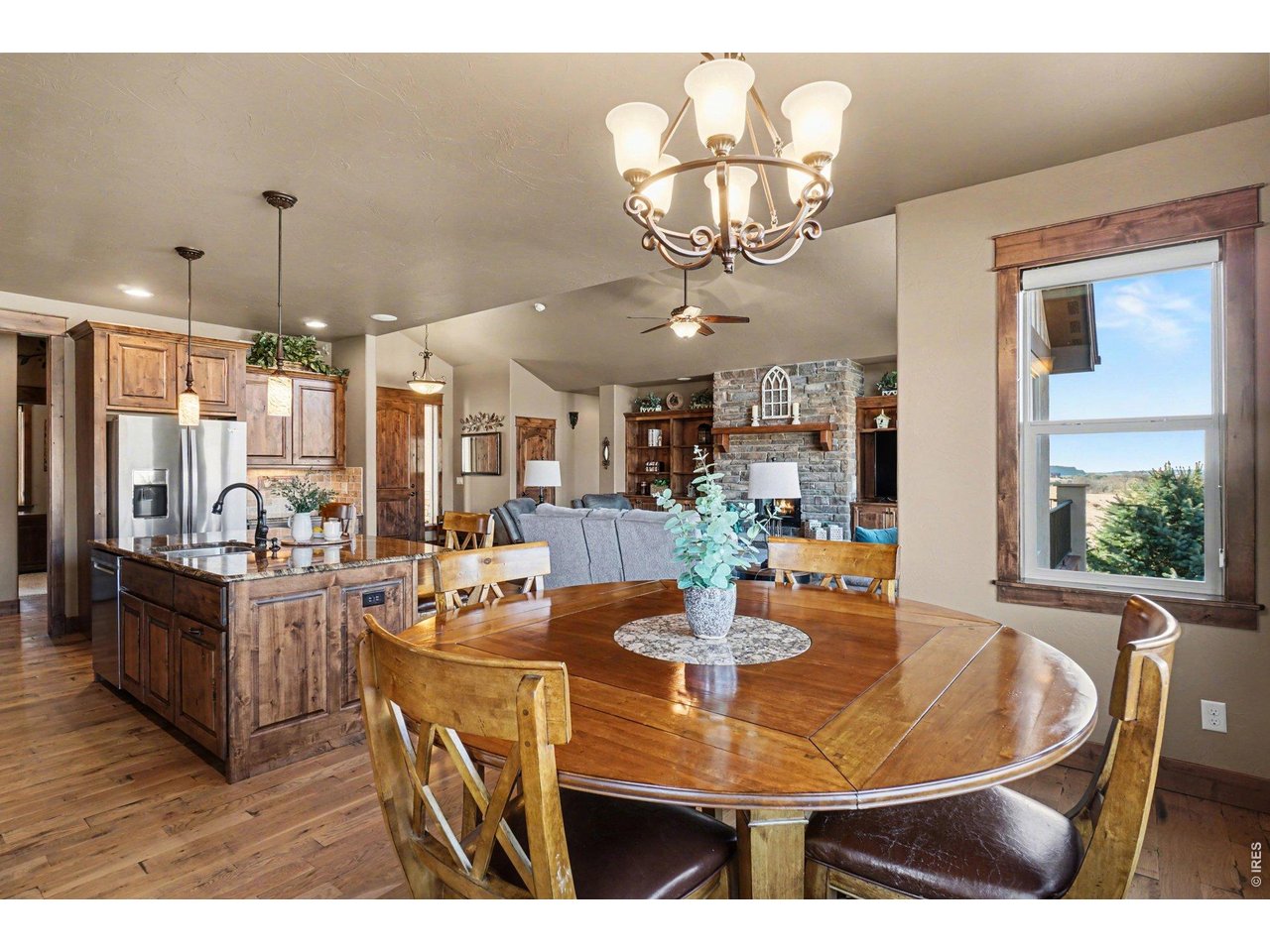 10723 Buckhorn Ridge Way Loveland, CO 80538 - Photo 14 of 50 a view of a dining room with furniture a chandelier and wooden floor